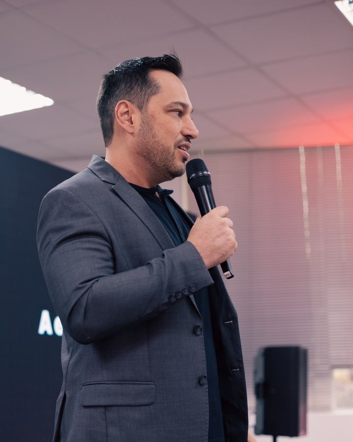 Lucien Newton falando ao microfone durante uma palestra